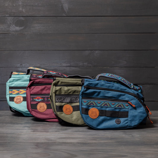 Four colorful crossbody bags in red, blue, green, and purple with patterns and leather logo patches