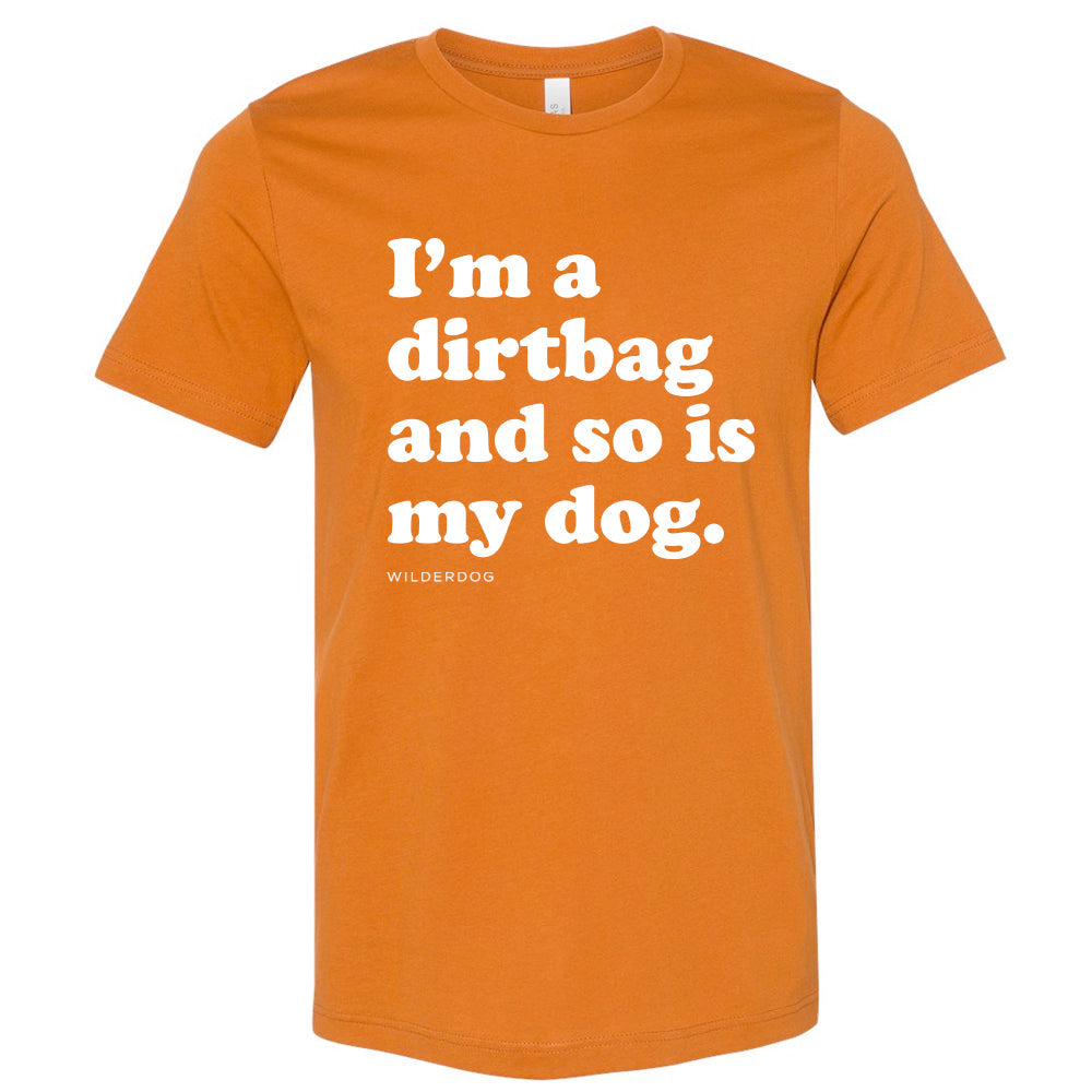 The Party Dog Tee Shirt is an orange unisex t-shirt featuring vibrant colors and white text that says, "I'm a dirtbag and so is my dog." Below the main message, the word "WILDERDOG" appears in smaller text. This shirt is perfect for anyone looking to make a bold statement.