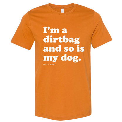 The Party Dog Tee Shirt is an orange unisex t-shirt featuring vibrant colors and white text that says, "I'm a dirtbag and so is my dog." Below the main message, the word "WILDERDOG" appears in smaller text. This shirt is perfect for anyone looking to make a bold statement.